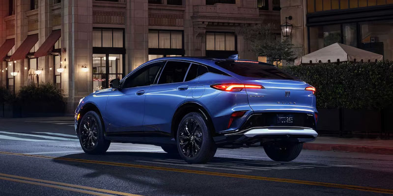A blue SUV parked on a city street at night, showcasing its rear design