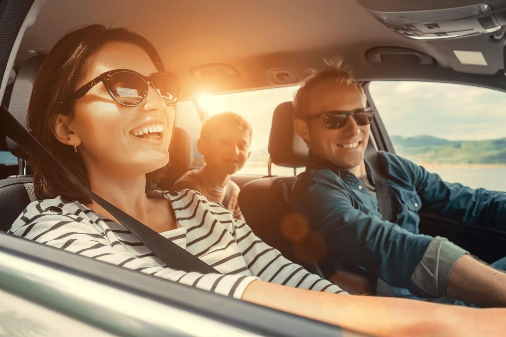 Smiling family in a car on a sunny day