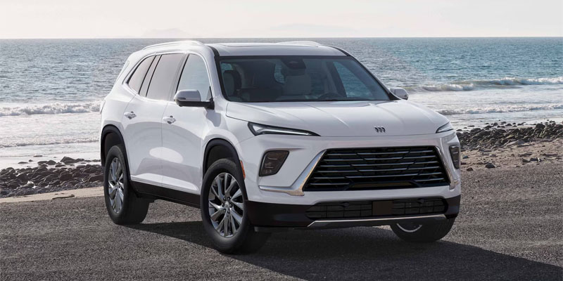 White SUV parked on beach near ocean